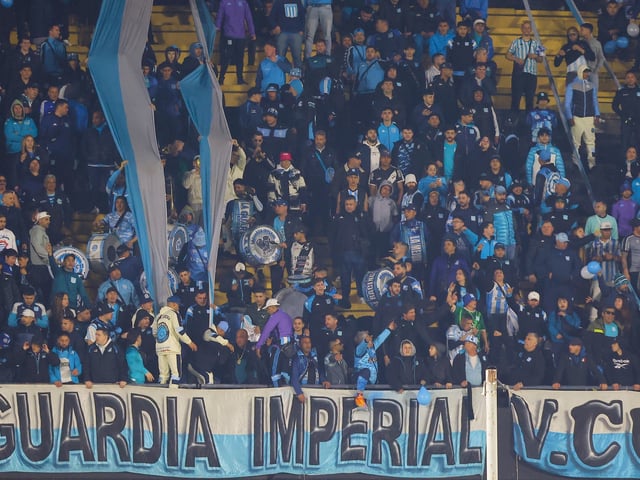 AMDEP155. MONTEVIDEO (URUGUAY), 12/08/2025.- Hinchas de Racing asisten este martes, a un partido de octavos de final de la Copa Libertadores entre Peñarol y Racing en el estadio Campeón del Siglo en Montevideo (Uruguay). EFE/ Gastón Britos