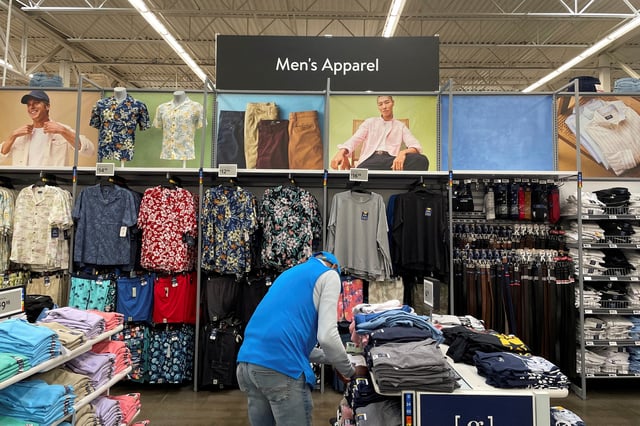 A Walmart employee folds clothes in the men's apparel section at a Walmart Supercenter, a day after U.S. President Donald Trump announced new tariffs, in North Bergen, New Jersey. U.S. April 3, 2025. REUTERS/Siddharth Cavale/File Photo