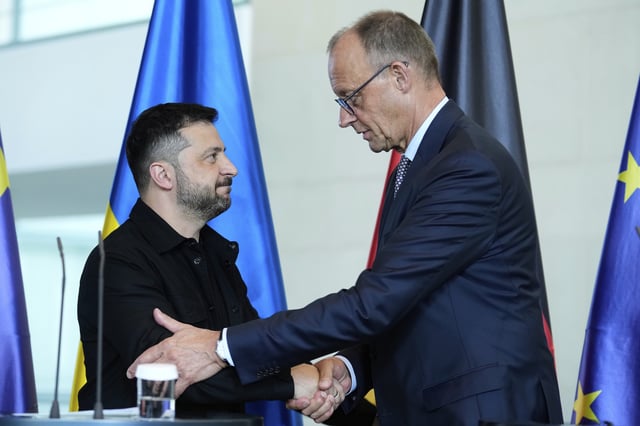 German Chancellor Friedrich Merz, right, and Ukrainian President Volodymyr Zelenskyy, left, shake hands after a joint press statement following talks with European and U.S. leaders in Berlin, Germany, Wednesday, Aug. 13, 2025. (AP Photo/Ebrahim Noroozi)