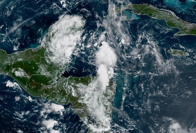 The weather satellite image of the tropical disturbance near the eastern coast of the Yucatan Peninsula was taken Wednesday. This disturbance will move into the Gulf of Mexico by Thursday.
