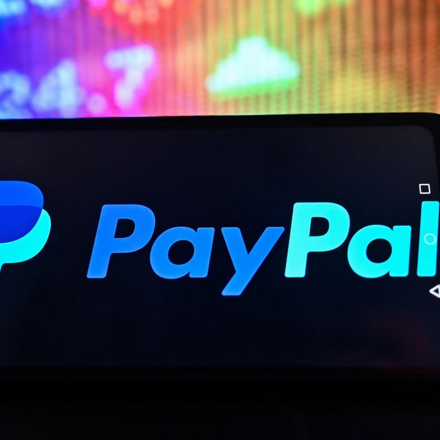 POLAND - 2023/02/01: In this photo illustration, a Paypal logo is displayed on a smartphone with stock market pricing in the background. (Photo Illustration by Omar Marques/SOPA Images/LightRocket via Getty Images)
