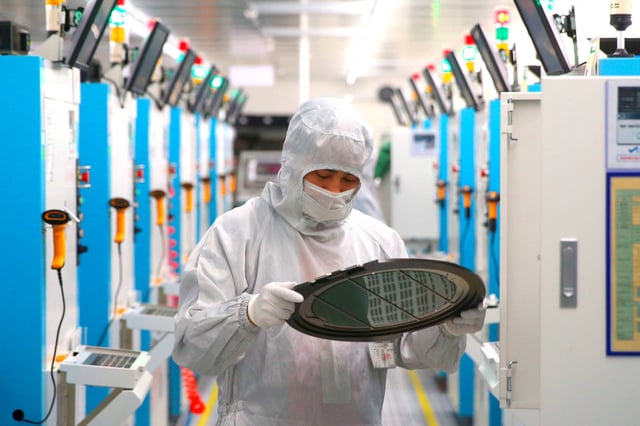 A worker can be seen in the mobile phone chip factory in Jiashan, Zhejiang, China, May 26, 2021 (uncredited photo for TopPhoto via AP Images).