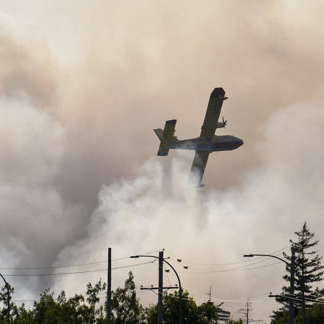 A water bomber tries to extinguish a wildfire near Bayers Lake at the edge of Halifax, Nova Scotia on August 12.