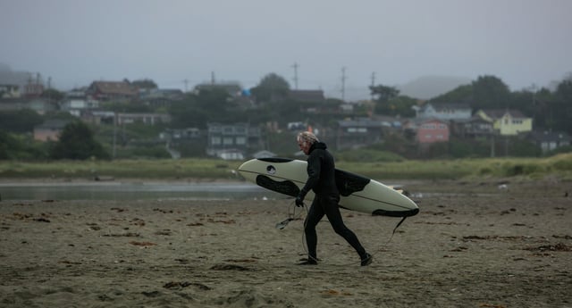 FILE: Aa surfer walks along the beach near Salmon Creek on Aug. 2, 2014, in Bodega Bay.