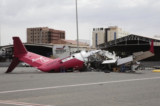 A damaged aircraft, previously destroyed during fighting between the Sudanese Armed Forces (SAF) and the paramilitary Rapid Support Forces (RSF), lies on the tarmac at Khartoum International Airport, Khartoum, Sudan, Wednesday, Aug. 13, 2025. (AP Photo/Marwan Ali)