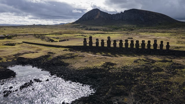FILE - Moai statues stand on Ahu Tongariki near the Rano Raraku volcano, top, on Rapa Nui, or Easter Island, Chile, Nov. 27, 2022. (AP Photo/Esteban Felix, File)