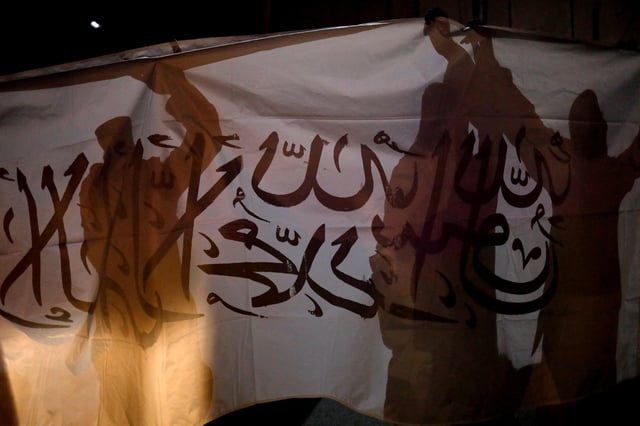 Taliban supporters hold an Islamic Emirate of Afghanistan flag on the first anniversary of the departure of U.S. forces from the country, on a street in Kabul, Afghanistan, August 30, 2022. REUTERS/Ali Khara/File Photo