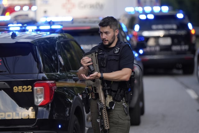 An armed Police officer prepares near the scene of shooting at the Emory University in Atlanta on Friday, Aug. 8, 2025. (AP Photo/Mike Stewart)