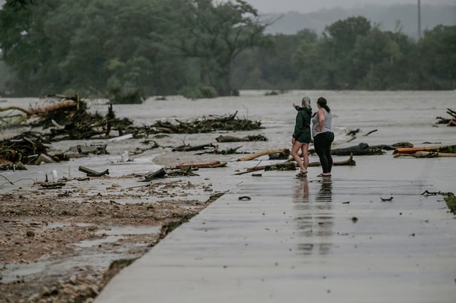 Two HTR RV Park employees look over the area where dozens of trailers were swept away by floodwaters from the Guadalupe River in the early morning hours of July 4.