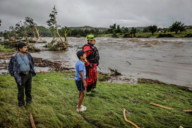 Two HTR RV Park employees look over the area where dozens of trailers were swept away by floodwaters from the Guadalupe River in the early morning hours of July 4.
