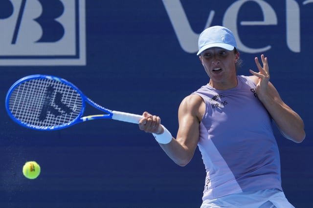 Aug 13, 2025; Cincinnati, OH, USA;  Iga Swiatek (POL) returns a shot against Sorana Cirstea (ROU) during the Cincinnati Open at the Lindner Family Tennis Center. Mandatory Credit: Aaron Doster-Imagn Images