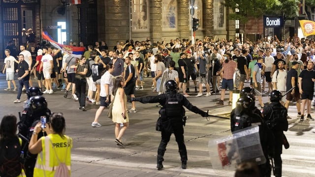 The rival groups hurled flares, rocks, firecrackers and bottles at each other in Belgrade.