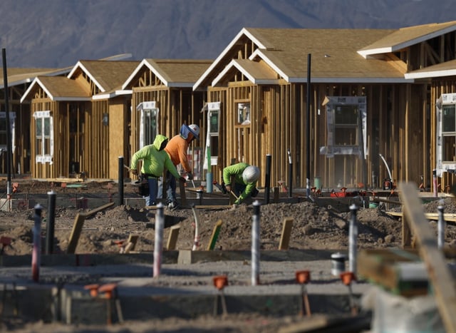 Construction workers build homes at a new housing development in Henderson, Nev.