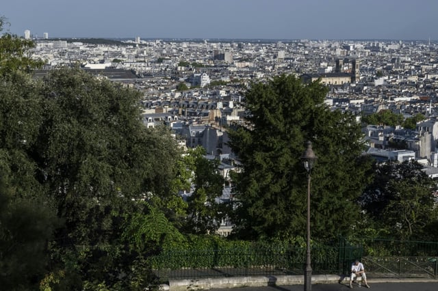 Un homme est assis sur un trottoir de la Butte Montmartre, à Paris, le 12 août 2025, en pleine canicule