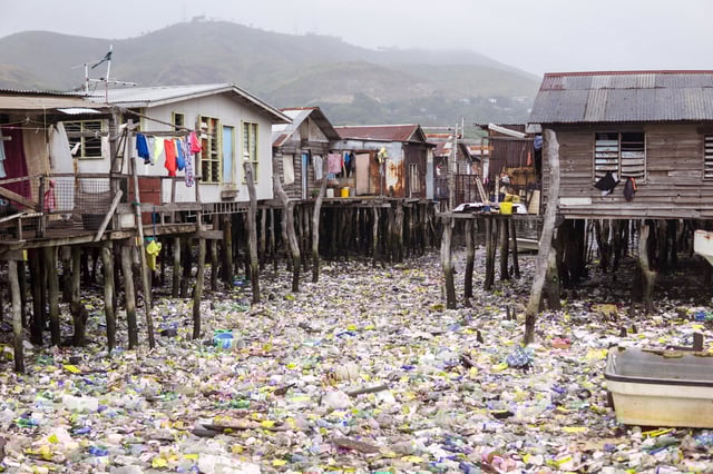 Waters filled with plastics in floating wooden village on the coast of Port Moresby, the capital of Papua New Guinea. Environmental problem, catastrophe