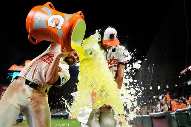 Jackson Holliday, derecha, de los Orioles de Baltimore, recibe un baño por parte de Jordan Westburg, izquierda, después de batear un doble durante la novena entrada para dejar tendidos en el terreno a los Marineros de Seattle, el miércoles 13 de agosto de 2025, en Baltimore. (AP Foto/Stephanie Scarbrough)