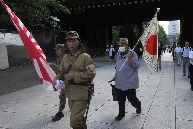 FILE - People clad in outdated military uniforms walk towards the main hall of the Yasukuni Shrine, which honors Japan's war dead, in Tokyo, Japan, on Aug. 15, 2024, as the country marks the 79th anniversary of its defeat in the World War II. (AP Photo/Hiro Komae, File)