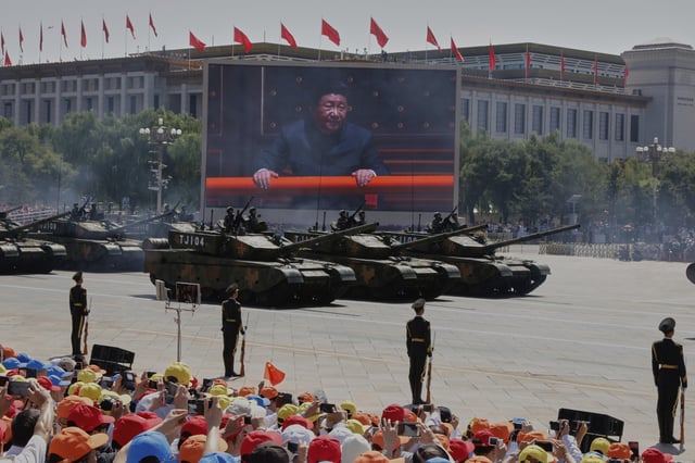 FILE - Chinese President Xi Jinping is displayed on a screen as Type 99A2 Chinese battle tanks take part in a parade commemorating the 70th anniversary of Japan's surrender during World War II held in front of Tiananmen Gate in Beijing, on Sept. 3, 2015. (AP Photo/Ng Han Guan, File)