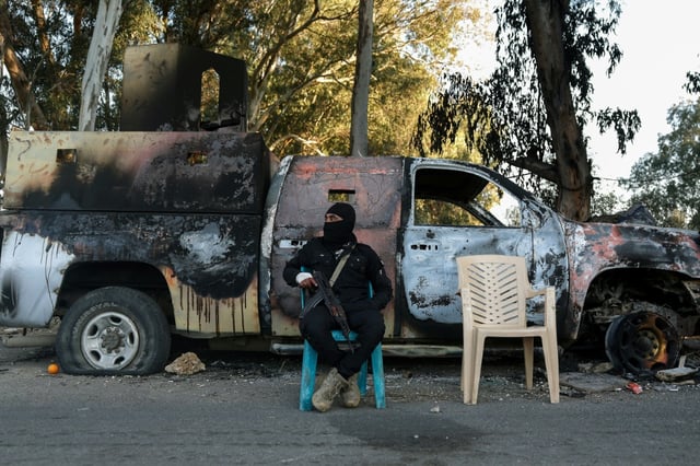 A member of the new Syrian authorities' security forces guards a checkpoint previously held by loyalists to Bashar al-Assad in the coastal province of Latakia in March
