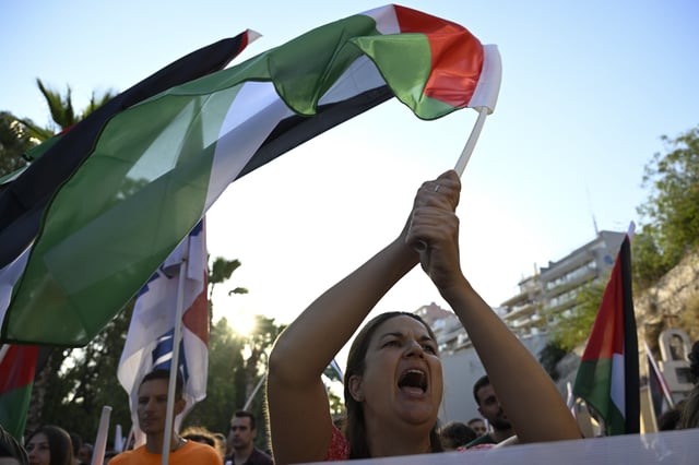 A protester shouts slogans as she waves a Palestinian flag, during a rally to protest the arrival of a cruise ship with Israelis, in Piraeus port, Greece, Thursday, Aug. 14, 2025. (AP Photo/Michael Varaklas)
