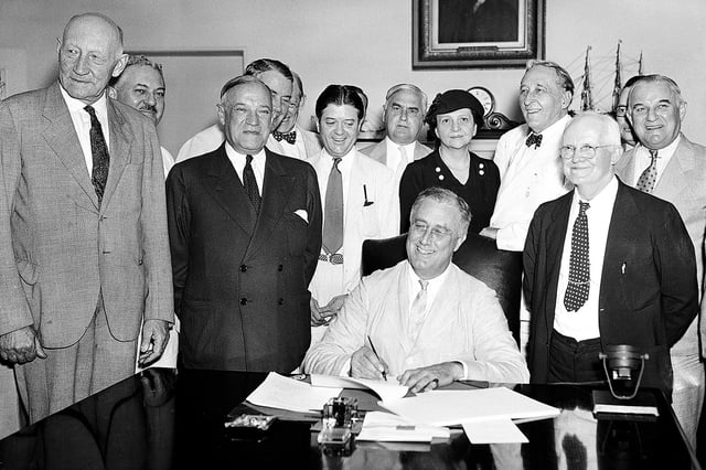FILE - President Franklin Roosevelt signs the Social Security Bill in Washington Aug. 14, 1935. (AP Photo, File)
