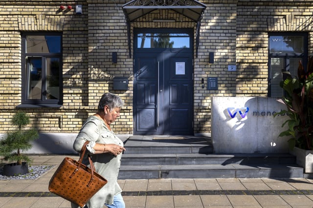 A woman walks past a Lithuania's AB Mano Bankas, which was imposed sanctioned by the Chinese Ministry of Commerce on Wednesday, in Vilnius, Lithuania, Thursday, Aug. 14, 2025. (AP Photo/Mindaugas Kulbis)