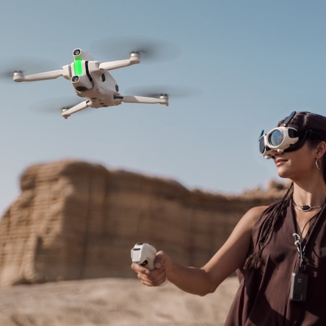 A woman flying the Antigravity A1 drone, wearing the Vision goggles and holding the Grip controller.