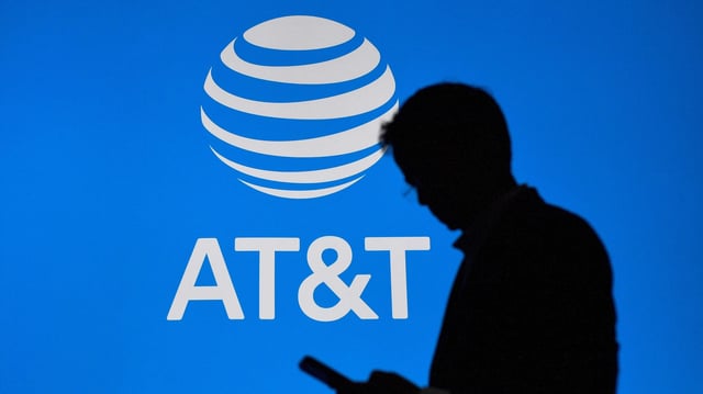 A visitor walks past US multinational telecommunications AT&amp;T logo at the Mobile World Congress (MWC), the telecom industry’s biggest annual gathering, in Barcelona on Feb. 27, 2023.