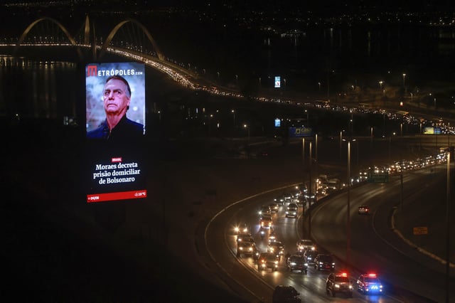 Supporters of former President Jair Bolsonaro participate in a caravan to protest his house arrest order by the Supreme Court, while passing an electronic billboard with his image, Monday, Aug. 4, 2025, in Brasilia, Brazil. (AP Photo/Luis Nova)