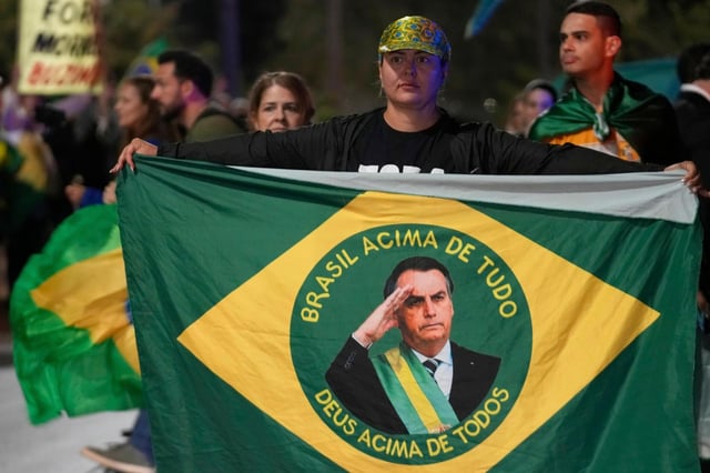 Manifestantes muestran su apoyo al expresidente de Brasil, Jair Bolsonaro, a la entrada del complejo donde vive, para denunciar la orden de arresto domiciliario emitida por el Supremo Tribunal Alexandre contra él, en Brasilia, Brasil, el 5 de agosto de 2025. (AP Foto/Eraldo Peres)