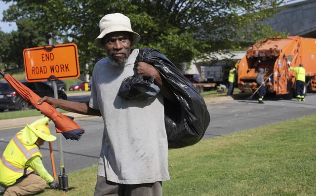 George, 67, walks away with what's left of his belongings, after the city put his mattress and other belongings in a dump truck, Thursday, Aug. 14, 2025, in Washington. (AP Photo/Jacquelyn Martin)