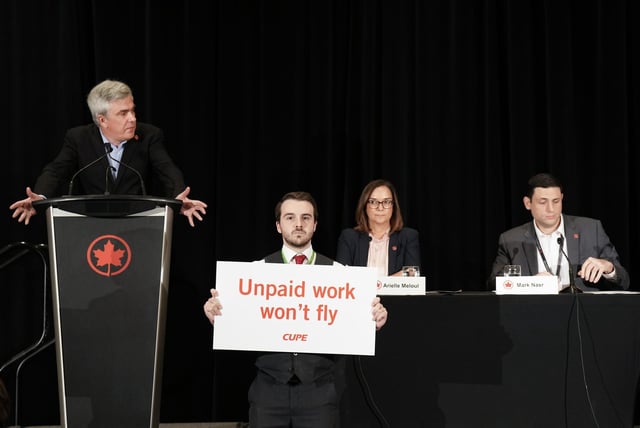 Air Canada executives are interrupted by Air Canada flight attendants during a press conference as a possible strike looms, in Toronto, on Thursday, Aug. 14, 2025. THE CANADIAN PRESS/Nathan Denette