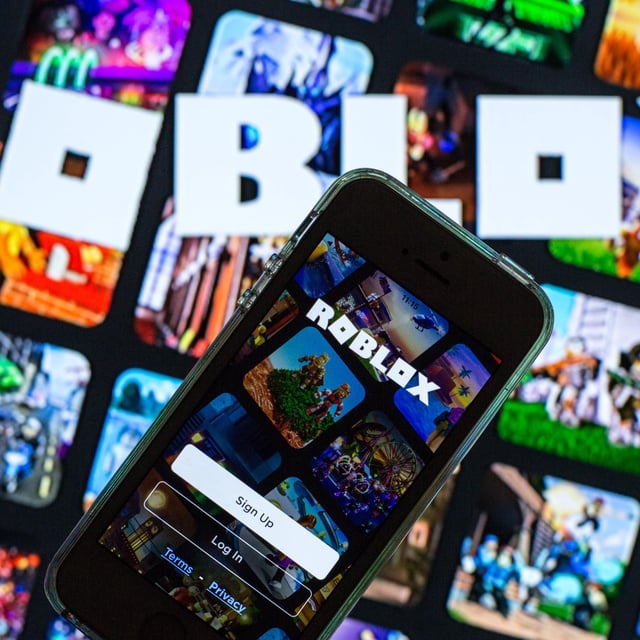 SPAIN - 2021/03/30: In this photo illustration, the Roblox app seen displayed on a smartphone screen and a Roblox logo in the background. (Photo Illustration by Thiago Prudêncio/SOPA Images/LightRocket via Getty Images)