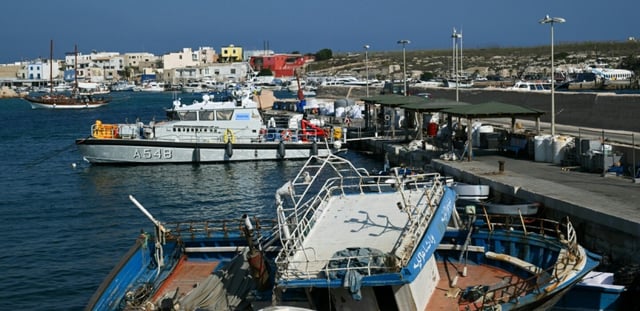 Un navire de patrouille de Frontex mouille dans le port de Lampedusa jeudi 14 août 2025, alors que les recherches se poursuivent pour tenter de retrouver des migrants ou les corps de nombreuses personnes encore portées disparues après un naufrage la veille qui a fait au moins 27 morts au large de la ville italienne
