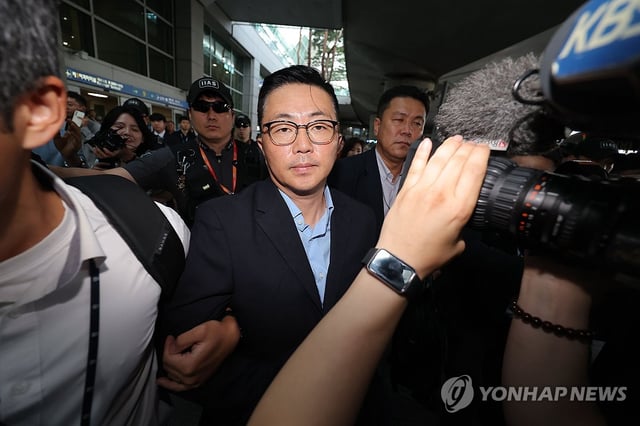 Kim Ye-seong (C), an associate of former first lady Kim Keon Hee, is taken in for questioning by a special counsel upon arrival at Incheon International Airport, west of Seoul, from Vietnam on Aug. 12, 2025. (Yonhap)