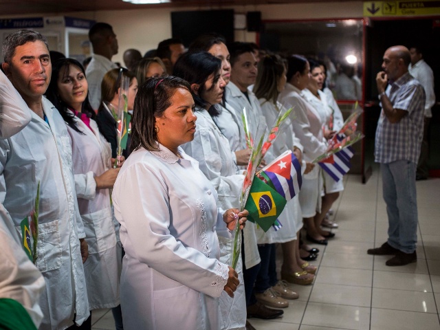Cuban doctors assemble to meet Cuba's President Miguel Diaz-Canel after landing in Havana, Cuba, Friday, Nov. 23, 2018. The first group of departing Cuban doctors left Brazil Friday after Cuba recalled more than 8,000 doctors rather than meet conditions imposed by Brazilian President-elect Jair Bolsonaro, who said the "More Doctors" program could continue only if doctors' pay isn't channeled through the Cuban government and if they could bring their families. (Desmond Boylan/AP)