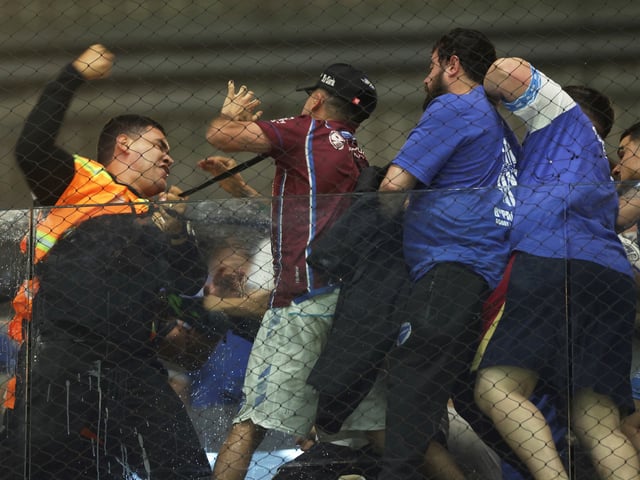 A security steward clashes with fans of Argentina's Godoy Cruz at the end of a Copa Sudamericana round of sixteen first leg soccer match against Brazil's Atletico Mineiro at Arena MRV, in Belo Horizonte, Brazil, Thursday, Aug. 14, 2025. (AP Photo/Tiago Trindade)