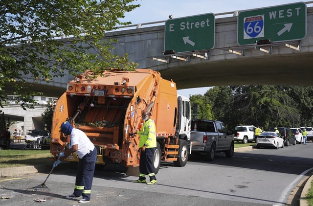 Items belonging to the homeless are removed from a tent encampment under an expressway and put in a garbage truck, Thursday, Aug. 14, 2025, where people who are homeless had been living in Washington. (AP Photo/Jacquelyn Martin)