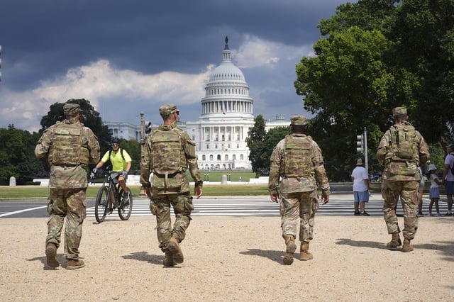 District of Columbia National Guard soldiers patrol on the National Mall, Thursday, August 14, 2025, in Washington. The U.S. Capitol is seen in the distance. (AP Photo/Jacquelyn Martin)