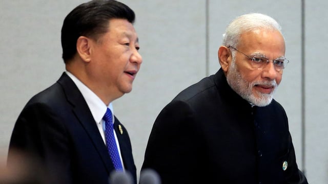 China's President Xi Jinping and India's Prime Minister Narendra Modi arrive for a signing ceremony during Shanghai Cooperation Organization (SCO) summit in Qingdao, Shandong Province, China June 10, 2018. 