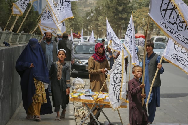 A man sells Taliban flags at a stand ahead of celebrations marking the fourth anniversary of the U.S. withdrawal from Afghanistan and the start of Taliban rule, in Kabul, Afghanistan, Thursday, Aug. 14, 2025. (AP Photo/Siddiqullah Alizai)