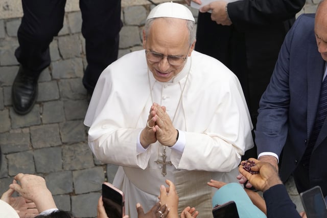Pope Leo XIV greets faithful at the end of the Angelus prayer in Castel Gandolfo, Italy, Friday, Aug.15, 2025. (AP Photo/Gregorio Borgia)