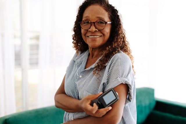 Smiling woman checking her blood sugar levels.