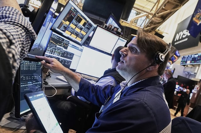 Trader Michael Milano works on the floor of the New York Stock Exchange, Friday, Aug. 15, 2025. (AP Photo/Richard Drew)