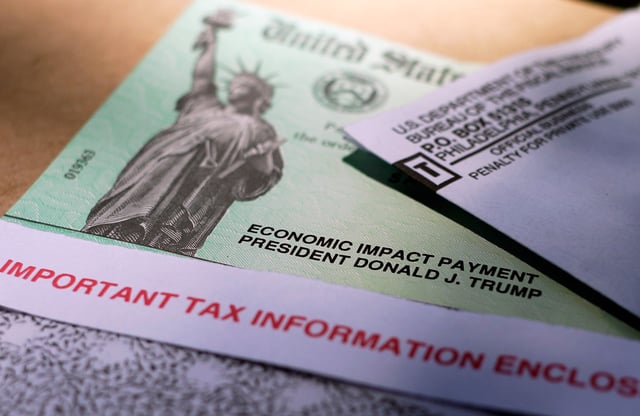 FILE - President Donald Trump's name is printed on a stimulus check issued by the IRS to help combat the adverse economic effects of the COVID-19 outbreak, April 23, 2020, in San Antonio. (AP Photo/Eric Gay, File)