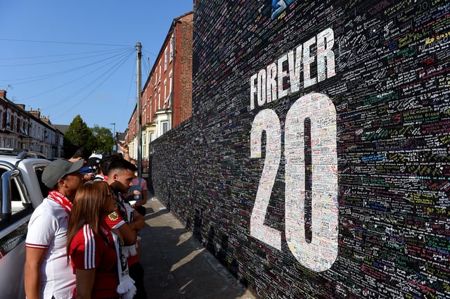 Soccer Football - Premier League - Liverpool v AFC Bournemouth - Anfield, Liverpool, Britain - August 15, 2025 Liverpool fans look at a tribute in memory of Diogo Jota outside the stadium before the match REUTERS/Peter Powell