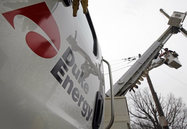 FILE - Duke Energy employees work on power lines in Charlotte, N.C., Feb. 14, 2012. (AP Photo/Chuck Burton, File)