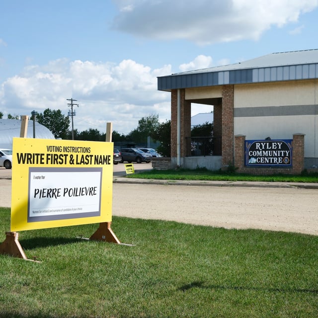 A large Pierre Poilievre election sign outside of the Ryley Community Centre being frequented by community members for advance polling, Ryley, Alberta. Photo taken August 11, 2025.