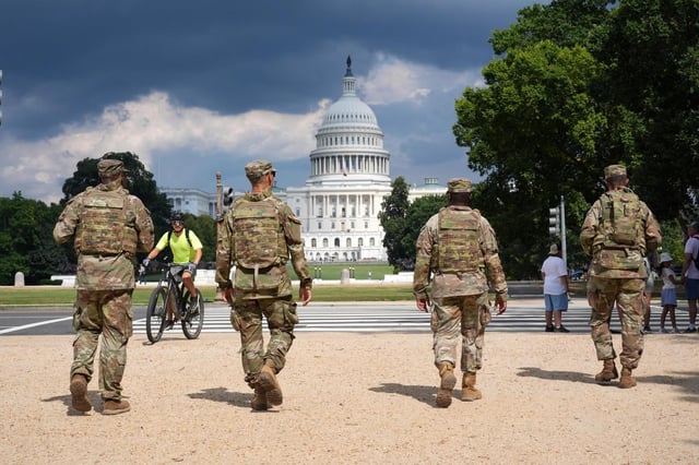District of Columbia National Guard soldiers patrol on the National Mall, Thursday, August 14, 2025, in Washington. The U.S. Capitol is seen in the distance. (AP Photo/Jacquelyn Martin)