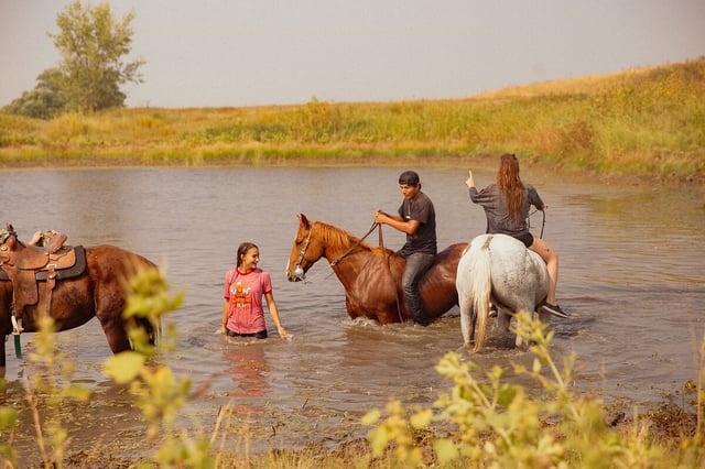 Ryder (Chancey Ryder Witt), Jesse (Jesse Thorson), and Porshia (Porshia Zimiga) play in the water with their horses in "East of Wall."
